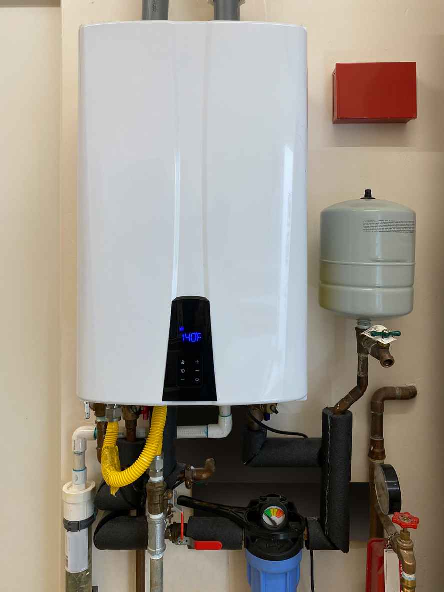 Tankless hot water heater mounted on wall of home